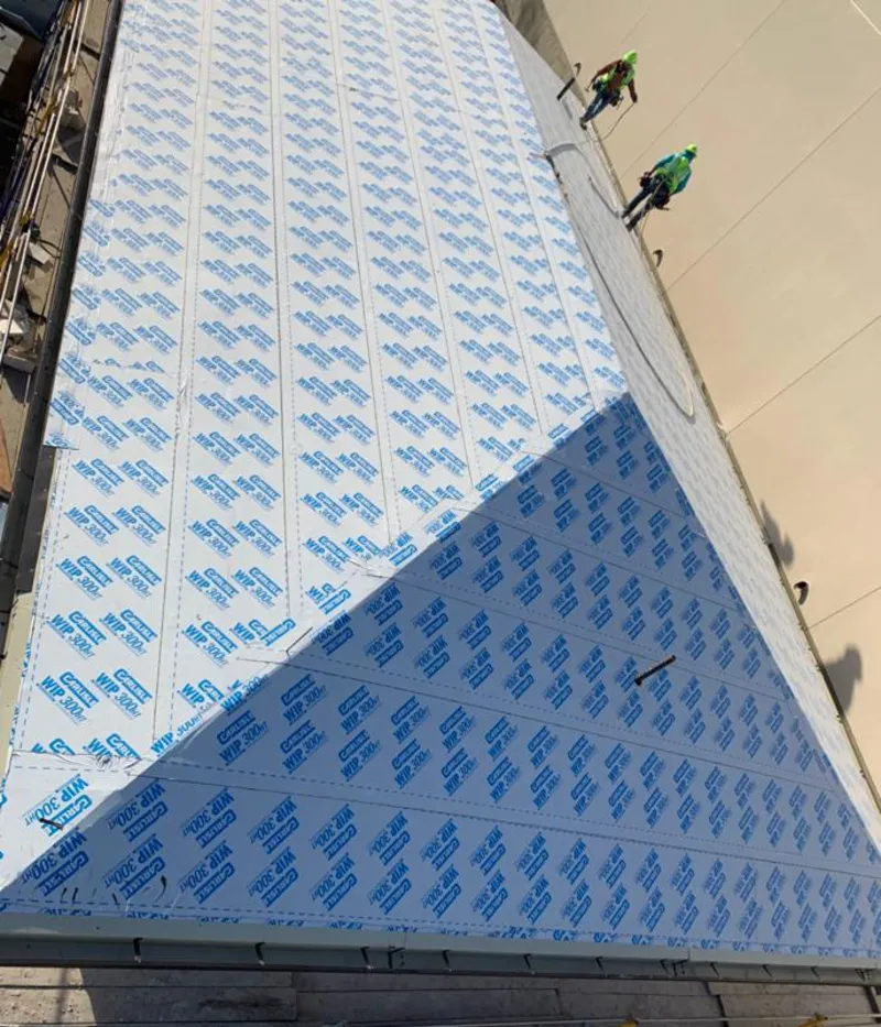 Professional roofers installing underlayment on a metal roof in Louisville